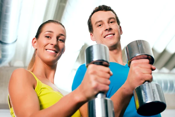 Paar im Fitnessstudio, die sich gegenseitig Konkurrenz machen — Stockfoto
