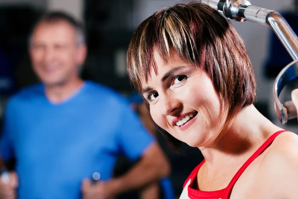 Mature woman in the gym lifting — Stock Photo, Image