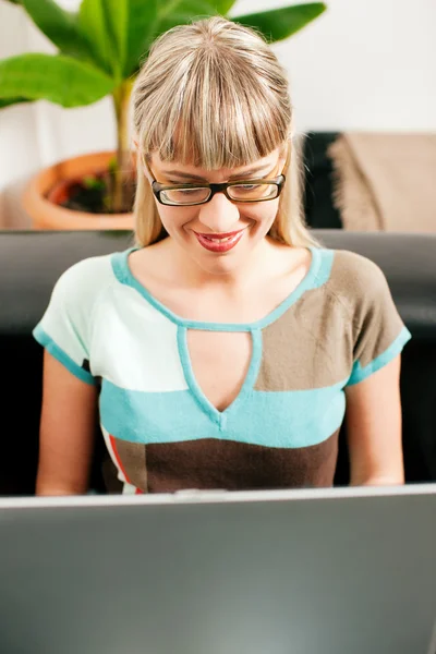 Kvinna - en telecommuterdoing administration av sitt företag från en laptop si — Stockfoto