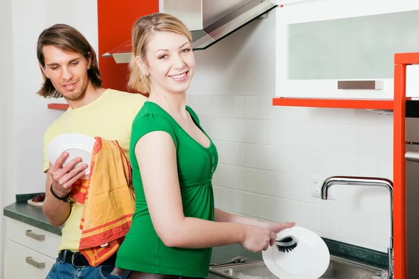 Couple cleaning their dishes in — Stock Photo, Image