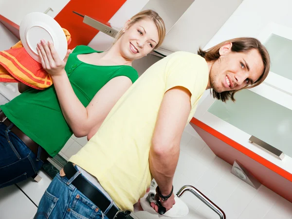 Casal limpando seus pratos em — Fotografia de Stock