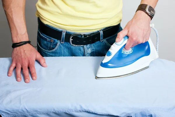 Man ironing a shirt in his — Stock Photo, Image