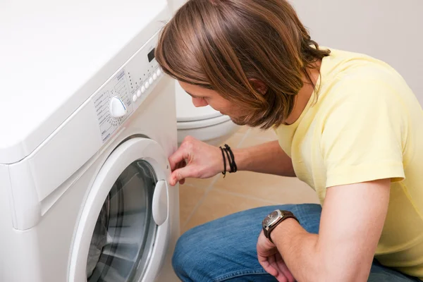 Мужчина стирает одежду с помощью — стоковое фото