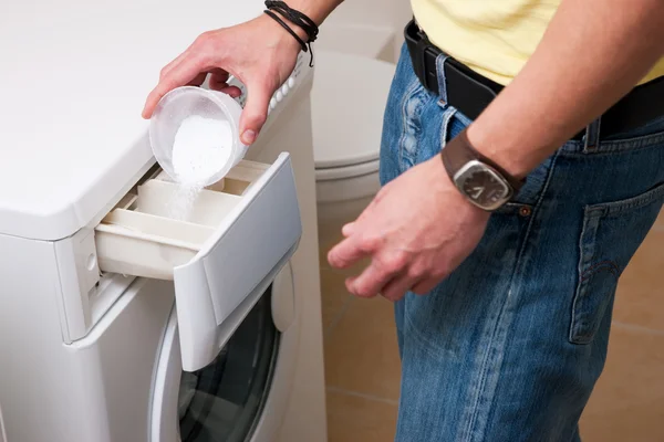 Мужчина стирает одежду с помощью — стоковое фото