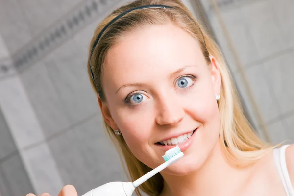 Giovane donna spazzolando il suo — Foto Stock