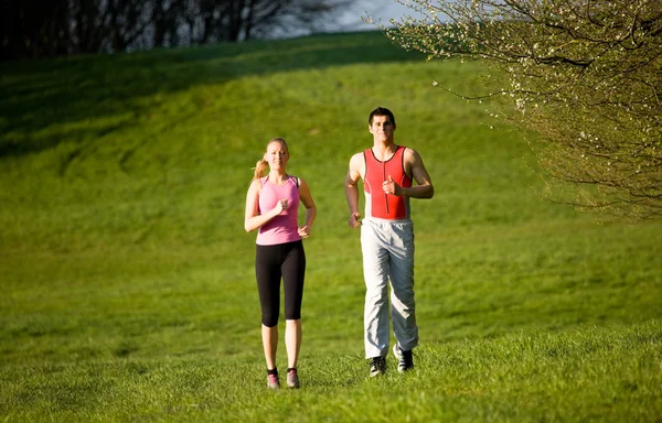 Спортивная молодая пара бегает трусцой — стоковое фото