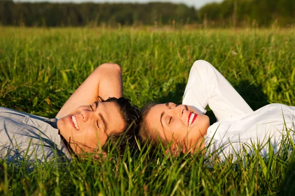 Mladý pár spolu leží na — Stock fotografie