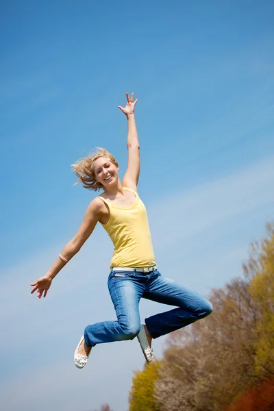 Jovem loira pulando alto — Fotografia de Stock