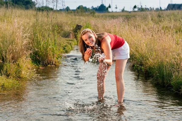 Kvinna som står i creek på sommaren — Stockfoto