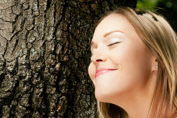 Meisje een boom knuffelen en — Stockfoto