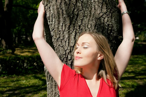 Chica abrazando a un árbol y —  Fotos de Stock