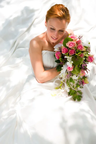 Bride sitting holding a bouquet — Stock Photo, Image