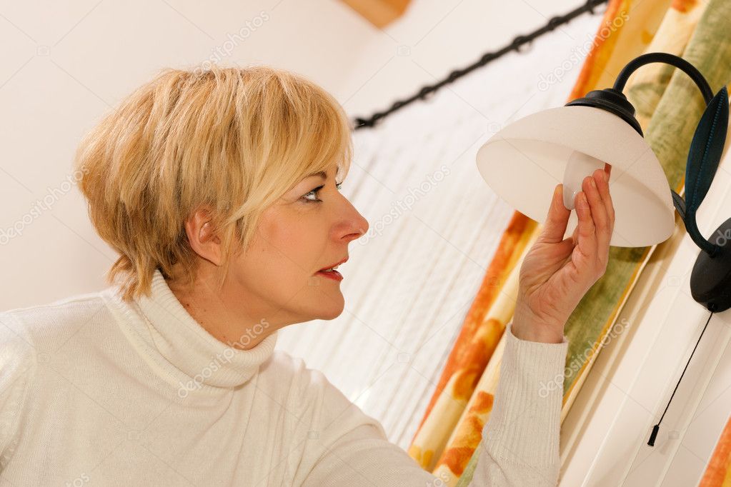 Woman changing a light bulb in