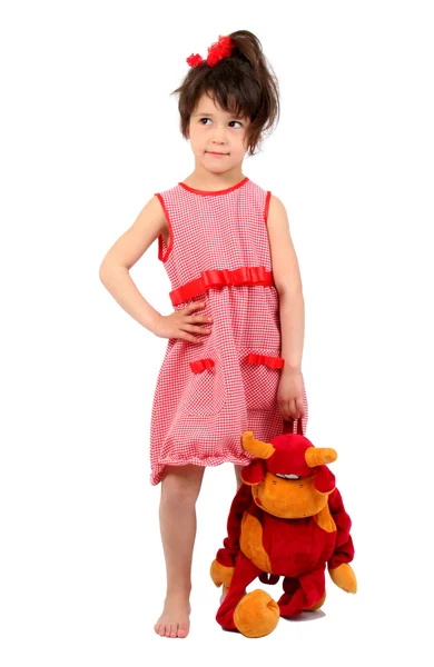 Улыбающаяся маленькая девочка, стоящая с коровьей игрушкой — стоковое фото