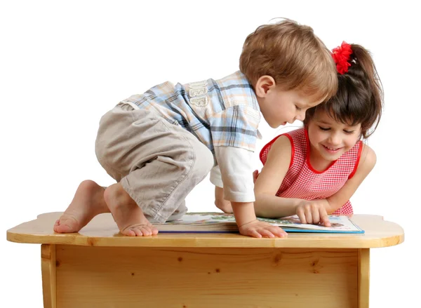 Dwa Uśmiechający Się Gry Dzieci Czytanie Książki Biurku — Zdjęcie stockowe