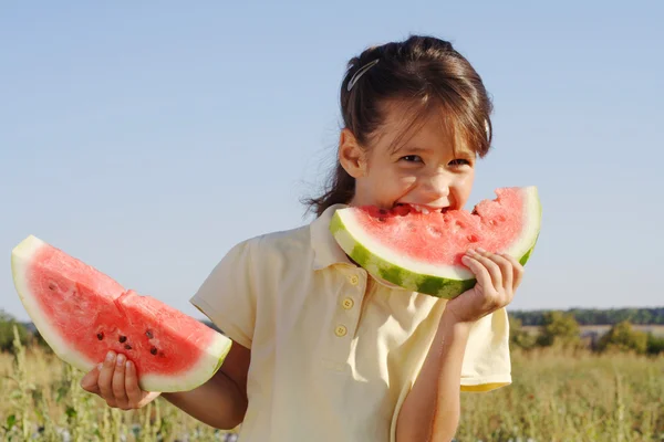 Lachende meisje met twee segmenten van watermeloen — Stockfoto