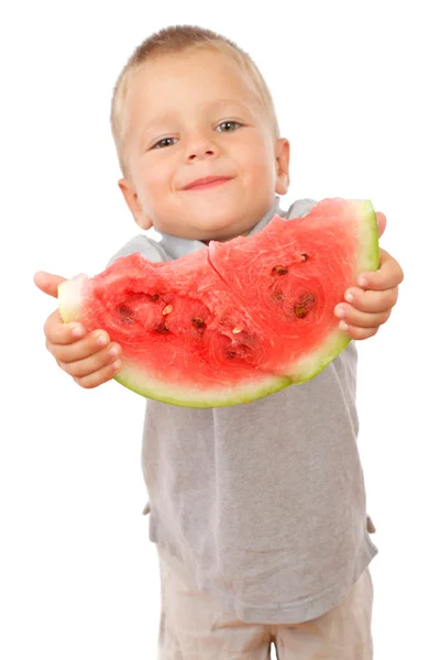 Kleine jongen rekken een segment van watermeloen — Stockfoto