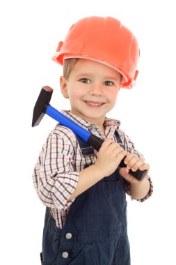 Little smiling builder in coveralls and helmet with hammer, isolated on white clipart