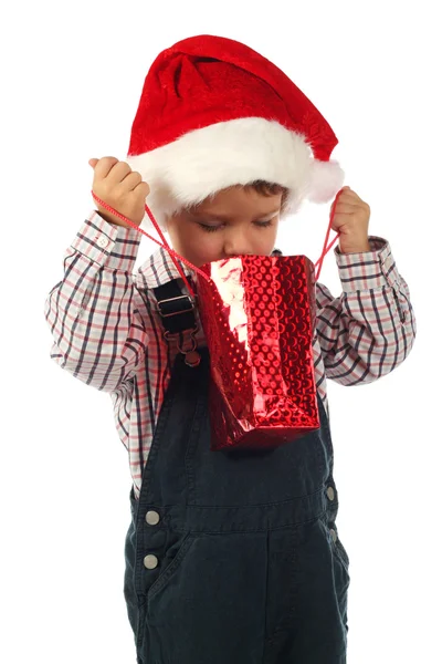 クリスマスのギフト袋を見て笑顔の小さな男の子 — ストック写真