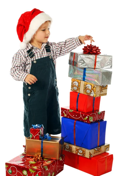 Ragazzino sorridente con scatole regalo di Natale molto — Foto Stock