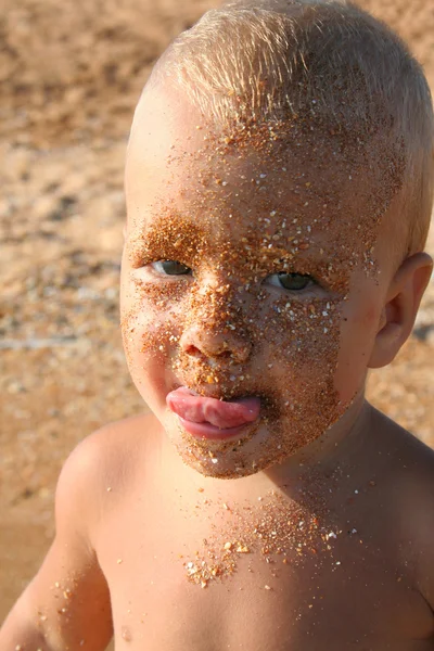 小さな男の子は砂で汚れた顔をして — ストック写真