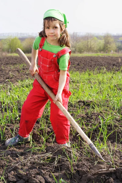 Κοριτσάκι σε πεδίο με σκαπάνη εργαλείο — Φωτογραφία Αρχείου
