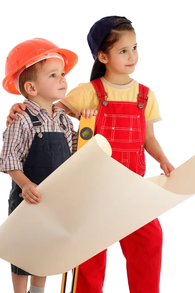 Two little builders planning with liquid level and blueprint — Stockfoto