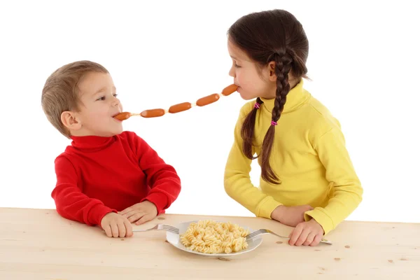 Маленькие дети разделяют цепь сосисок — стоковое фото