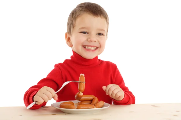 Улыбающийся мальчик с сосисками на вилке — стоковое фото