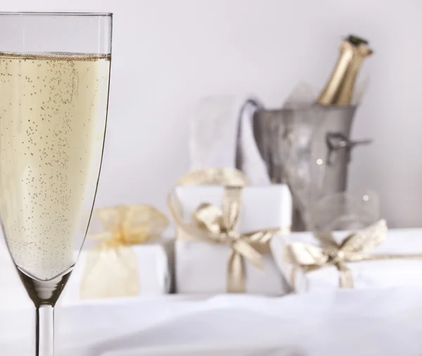 Kieliszek szampana i prezenty — Zdjęcie stockowe