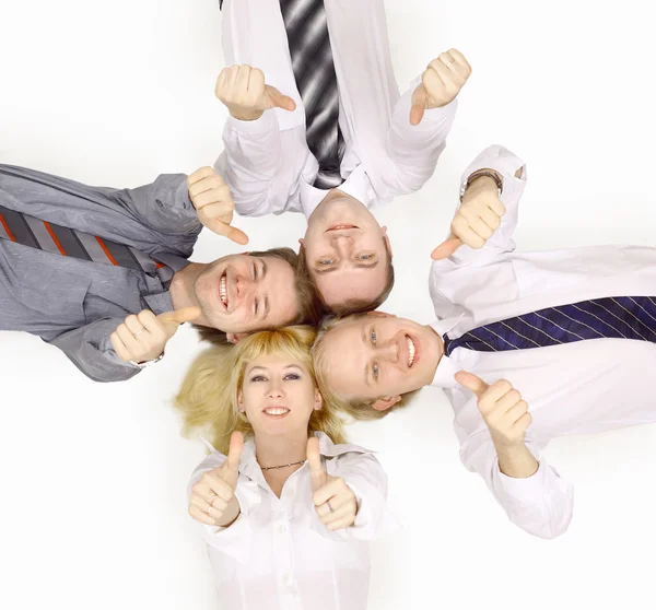 Glückliches Team von Geschäftskollegen, die im Kreis liegen und ihre Daumen zeigen — Stockfoto