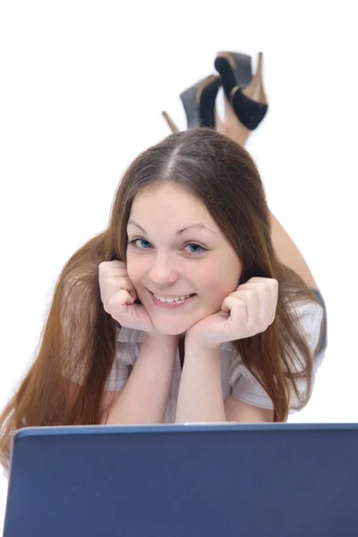Menina sorridente trabalha com o laptop deitado no chão — Fotografia de Stock
