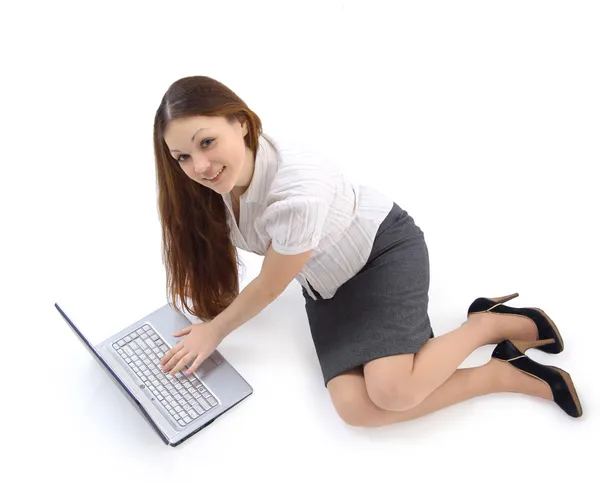 Усміхнена дівчина працює з ноутбуком, що лежить на підлозі — стокове фото