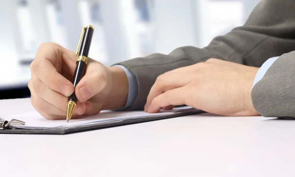 Close-up of business person hand with pen over document Stock Photo