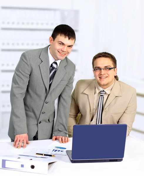 Dois homens de negócios bonitos trabalhando juntos em um projeto sentado em uma mesa i — Fotografia de Stock