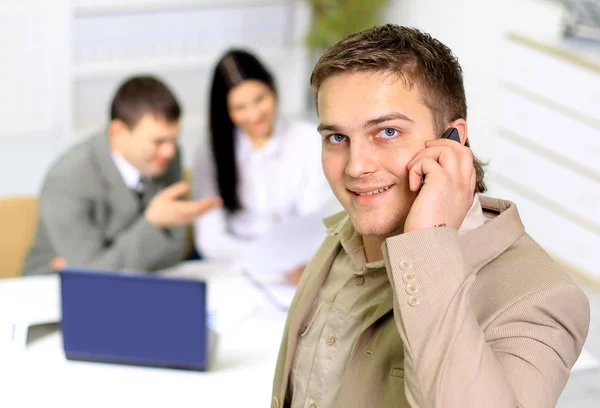 Jeune homme d'affaires souriant appelant au téléphone au bureau — Photo