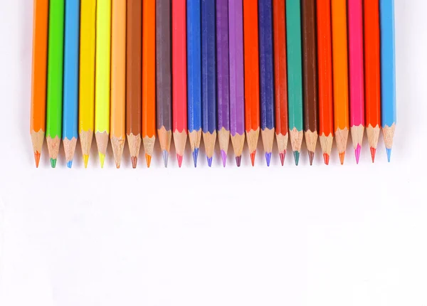 Цветные карандаши лежат на белом столе — стоковое фото
