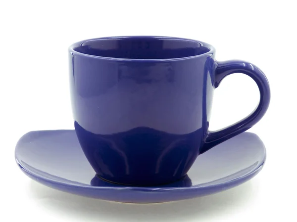 Темно-синяя чашка на тарелке — стоковое фото