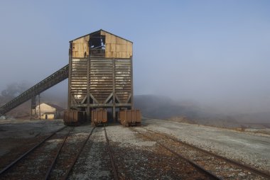 Mineral loading conveyor and freight cars clipart