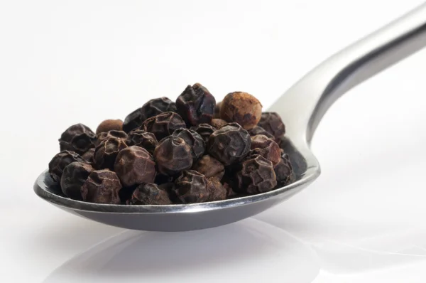 Black pepper in a spoon — Stock Photo, Image