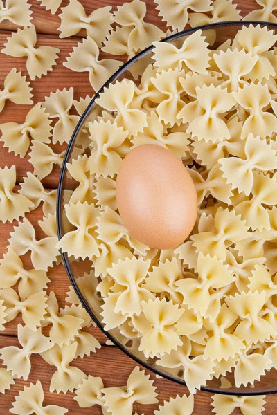 Raw pasta and an egg — Stock Photo, Image