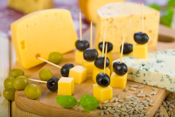 Tábua de queijo, azeitonas pretas e verdes . — Fotografia de Stock