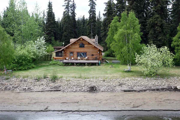 Casa in legno sulla riva del fiume in Alaska Immagini Stock Royalty Free