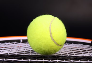 Tennis racket and ball on black clipart