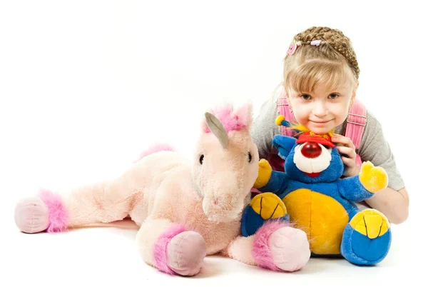 Flicka omgiven av hennes leksaker — Stockfoto