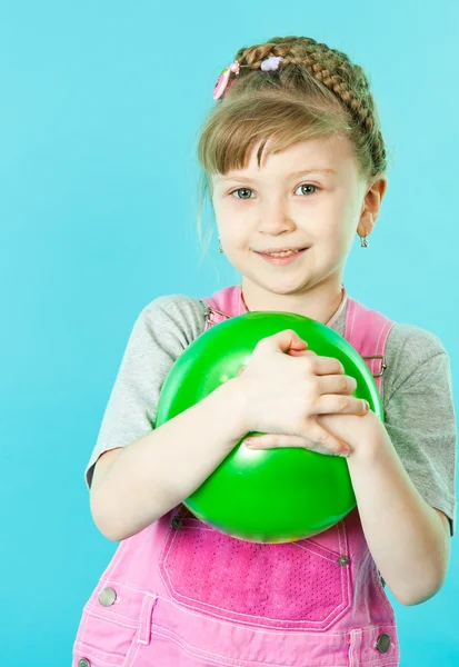 A girl playing with a green ball — Stock Photo, Image