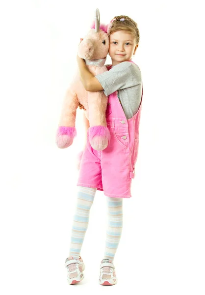 Девушка и ее игрушечный единорог — стоковое фото