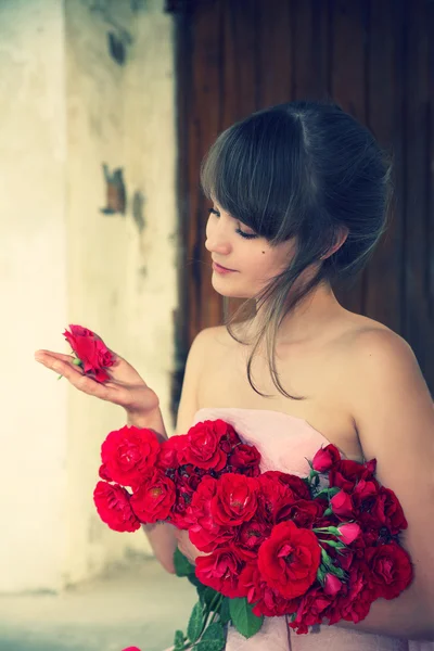 Joven hermosa chica con un ramo de rosas — Foto de Stock