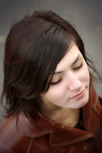 stock image A beautiful young girl is in a brown jacket