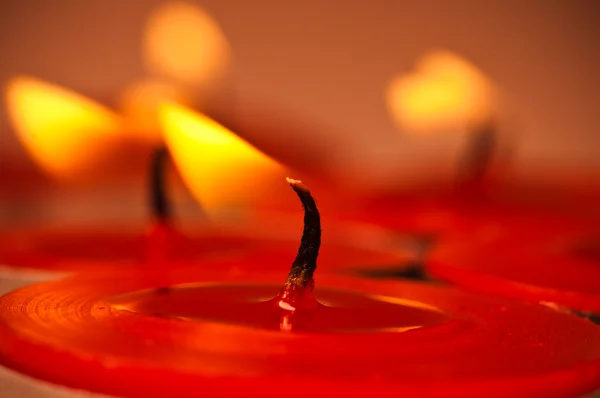 红色蜡烛用黄色火灾和黑色灯芯 图库图片